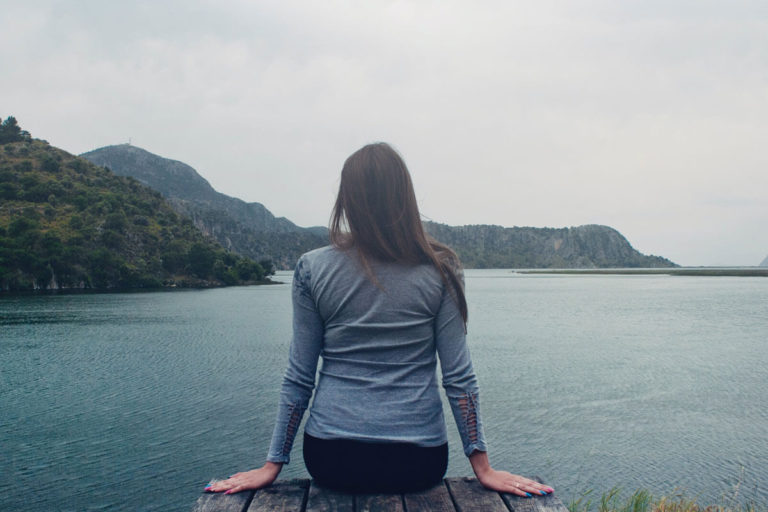 girl sitting on a dock looking at the water