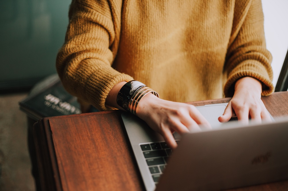 Hands typing on a laptop