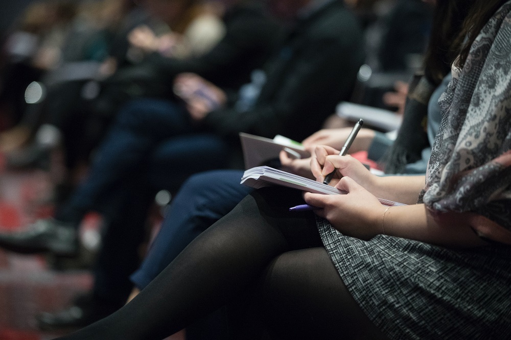 journalists taking notes by hand at an event