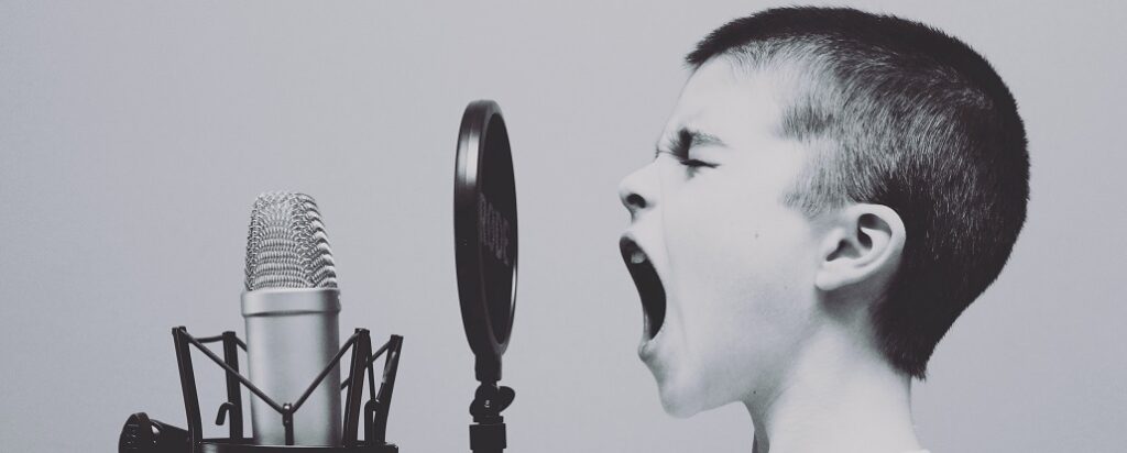 Young person shouting into a microphone