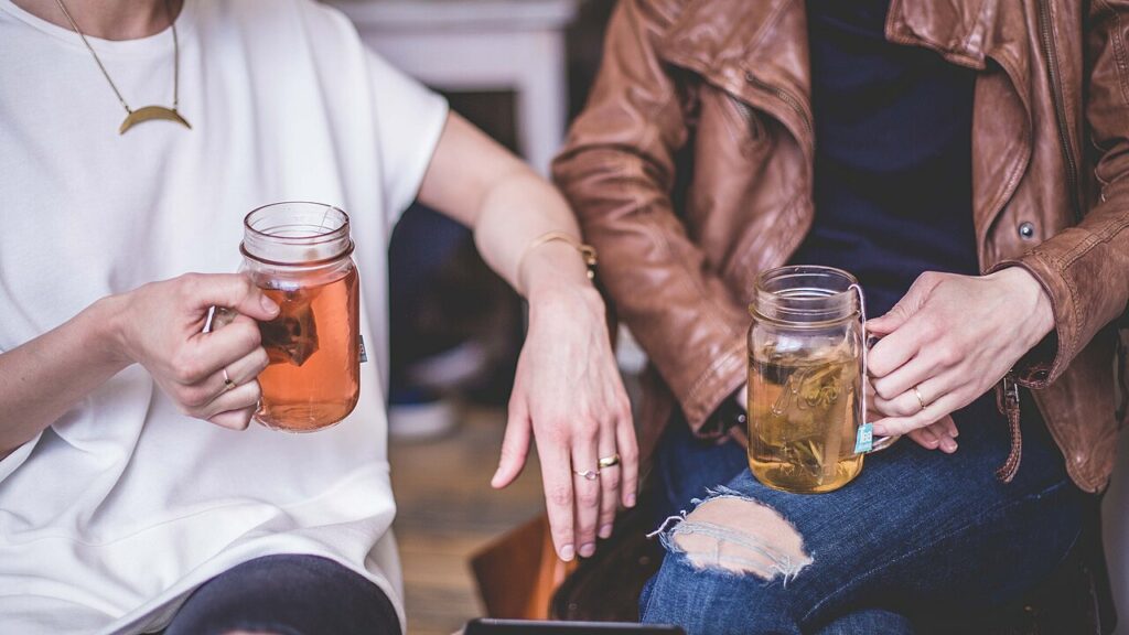 Wikimedia stock image of two people sitting and talking holding tea